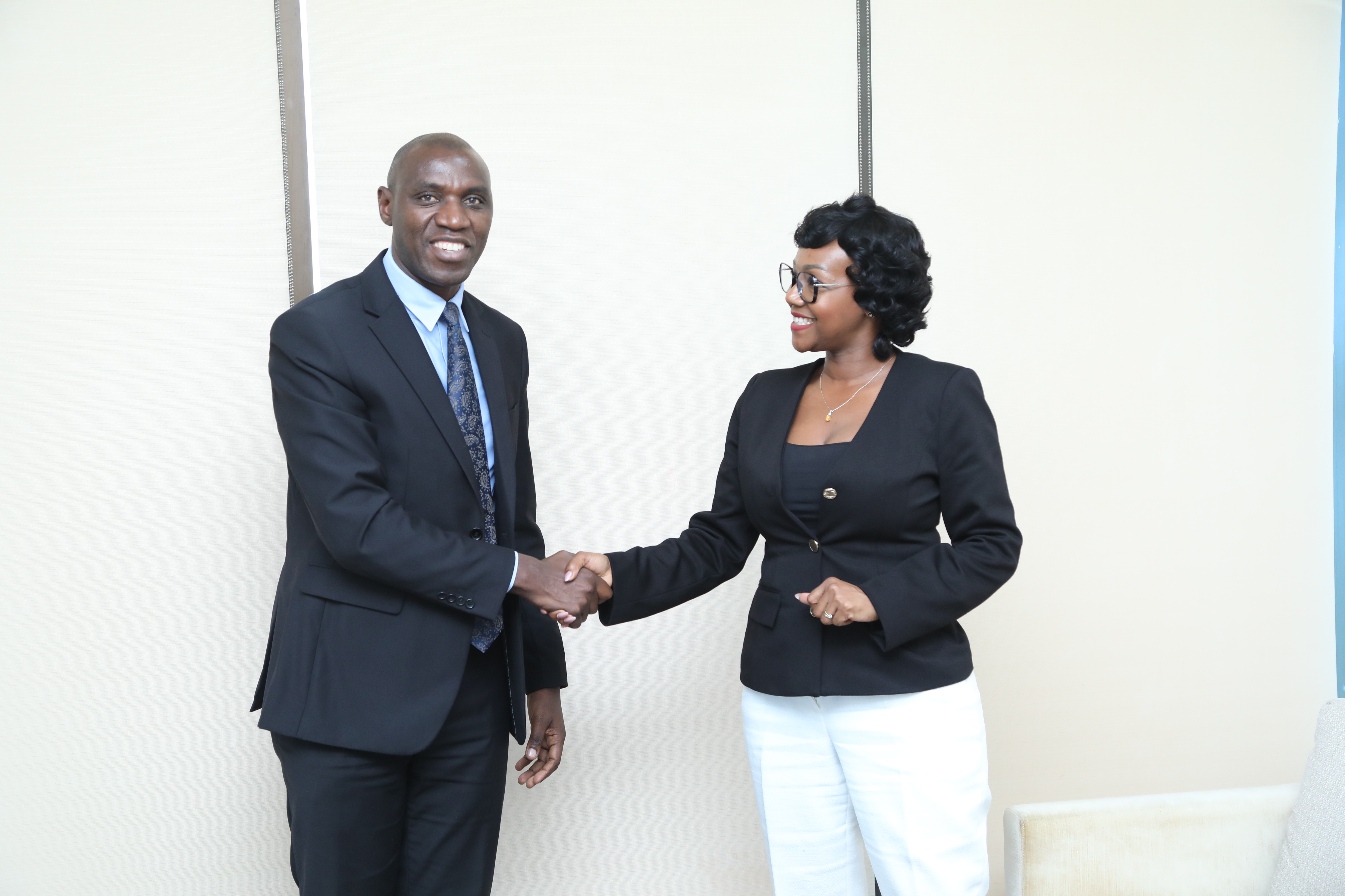 Rosalynn Mworia, Managing Director of Mwananchi Communications, shaking hands with Imani John, CEO of Access Bank, signifying a partnership between media and finance.